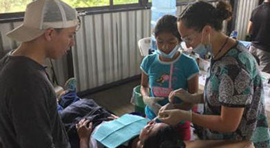 Adults and children work together on a craft project at Smile Lodge outdoor facility.