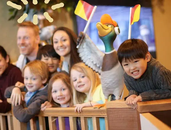 Family gathered around wooden railing at Smile Lodge during holiday celebration with festive decorations visible.