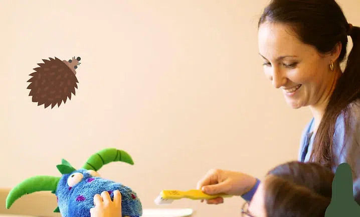 Woman playing with toddler using colorful toys at The Smile Lodge daycare center.