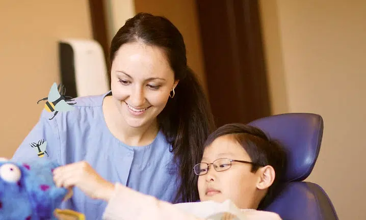 Woman and child smiling together in dental office setting during examination or consultation.