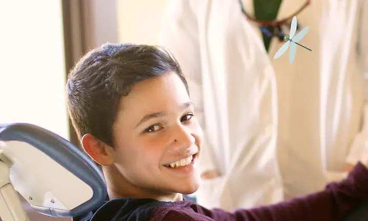 Young boy smiling at camera in bright indoor room at Smile Lodge facility.