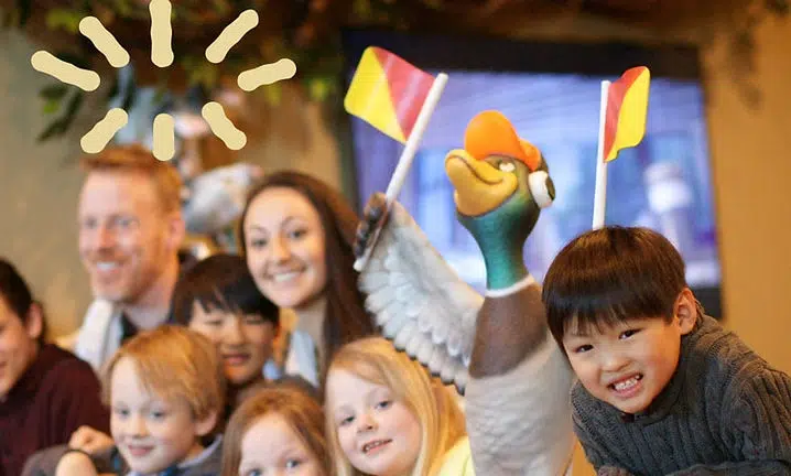 Family gathering at Smile Lodge with children and adults smiling indoors near decorative artwork.