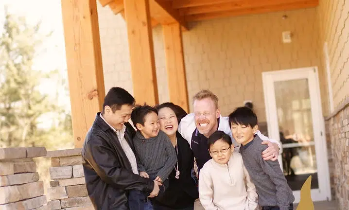 Group of six people standing together on a wooden porch at Smile Lodge.