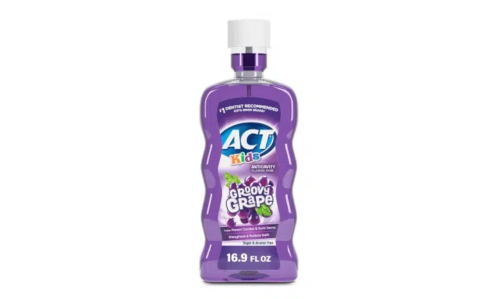 ACT mouthwash bottle with purple liquid and white cap on white background.
