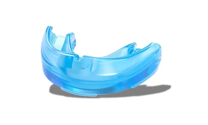 Blue dental night guard or bite splint on white background with shadow