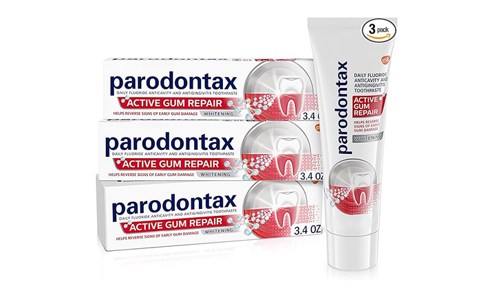 Three Parodontax toothpaste tubes and one applicator displayed against white background.